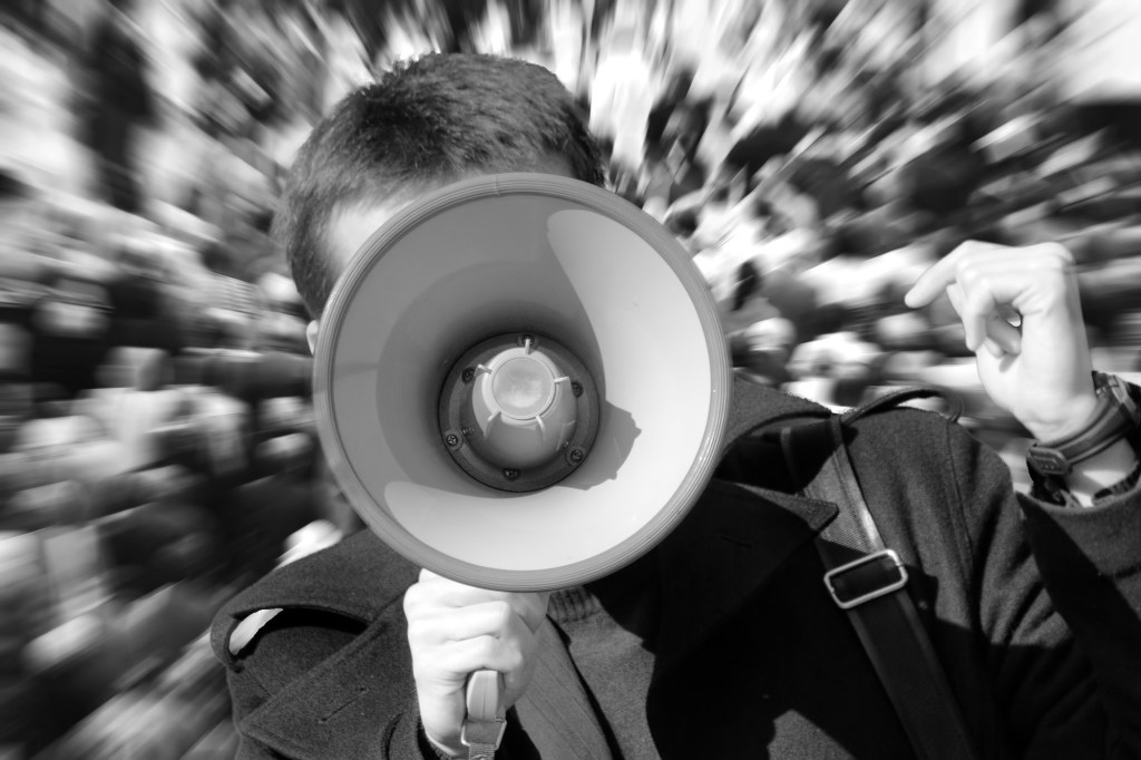 boy shouting into megaphone black and white