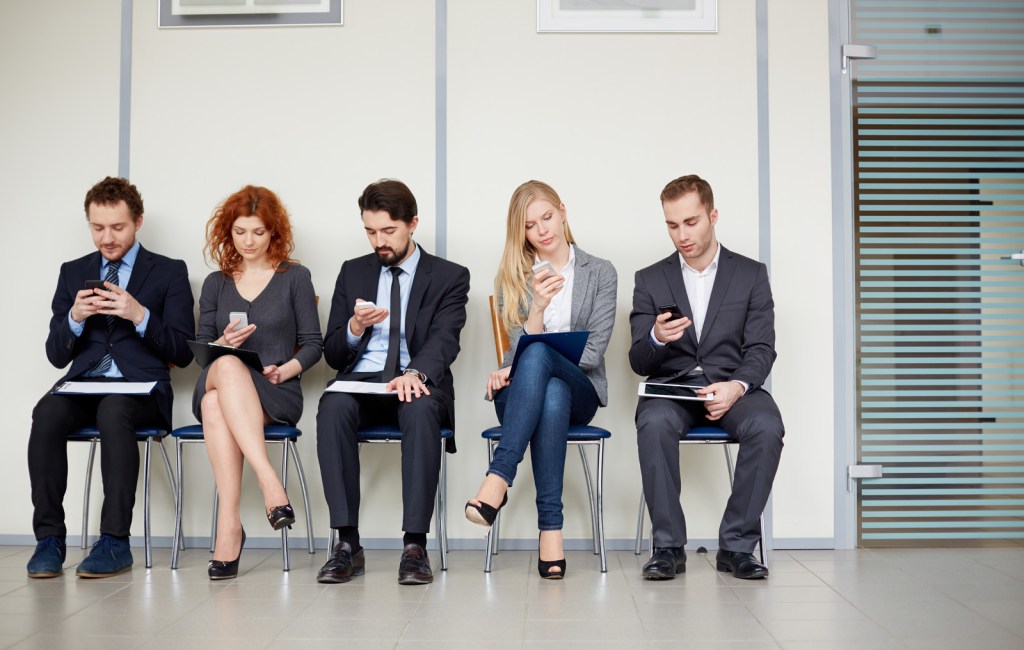 Group of business people with various mobile devices.