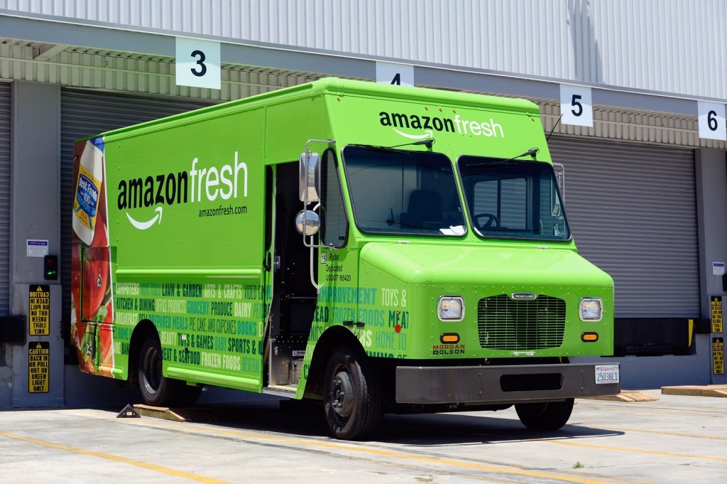 Bright green Amazon Fresh truck backed up to loading dock