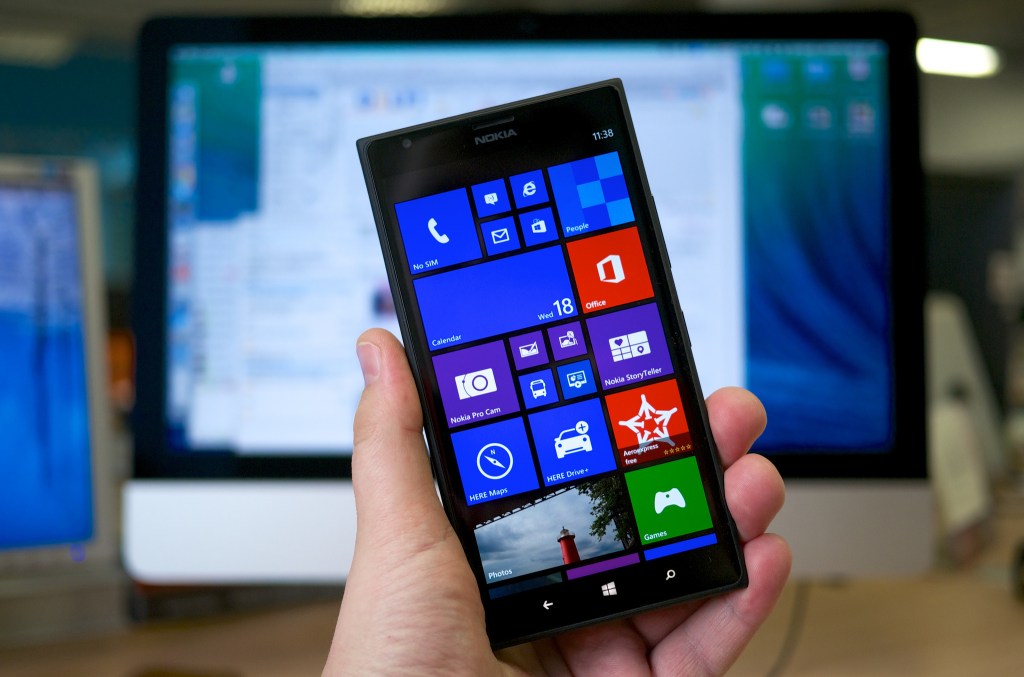 Hand holding a Lumia 1520 phone running Windows mobile.
