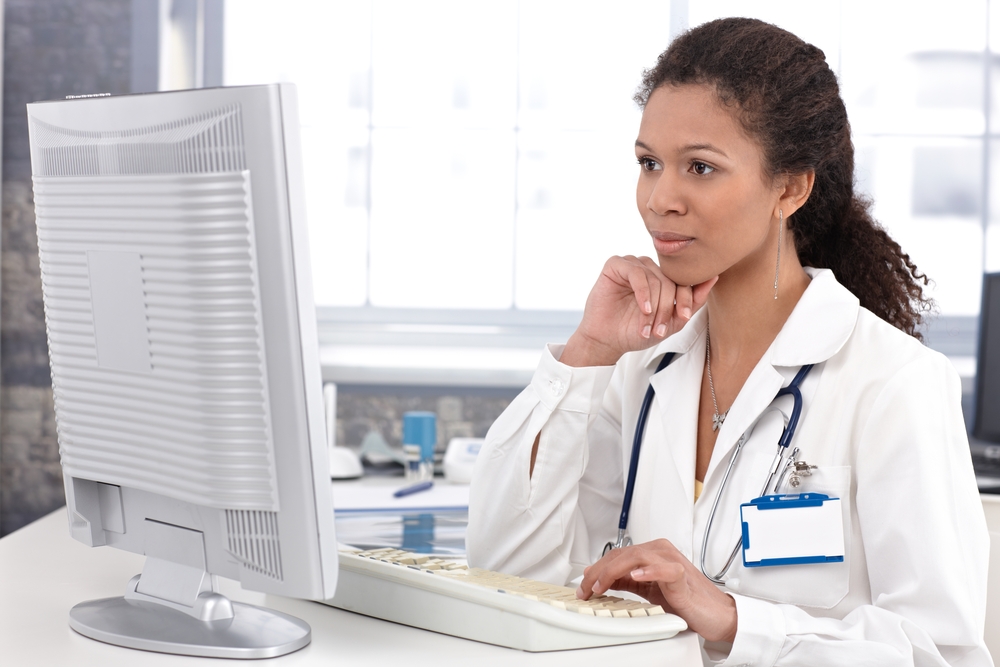 Physician looking at information on a large monitor.