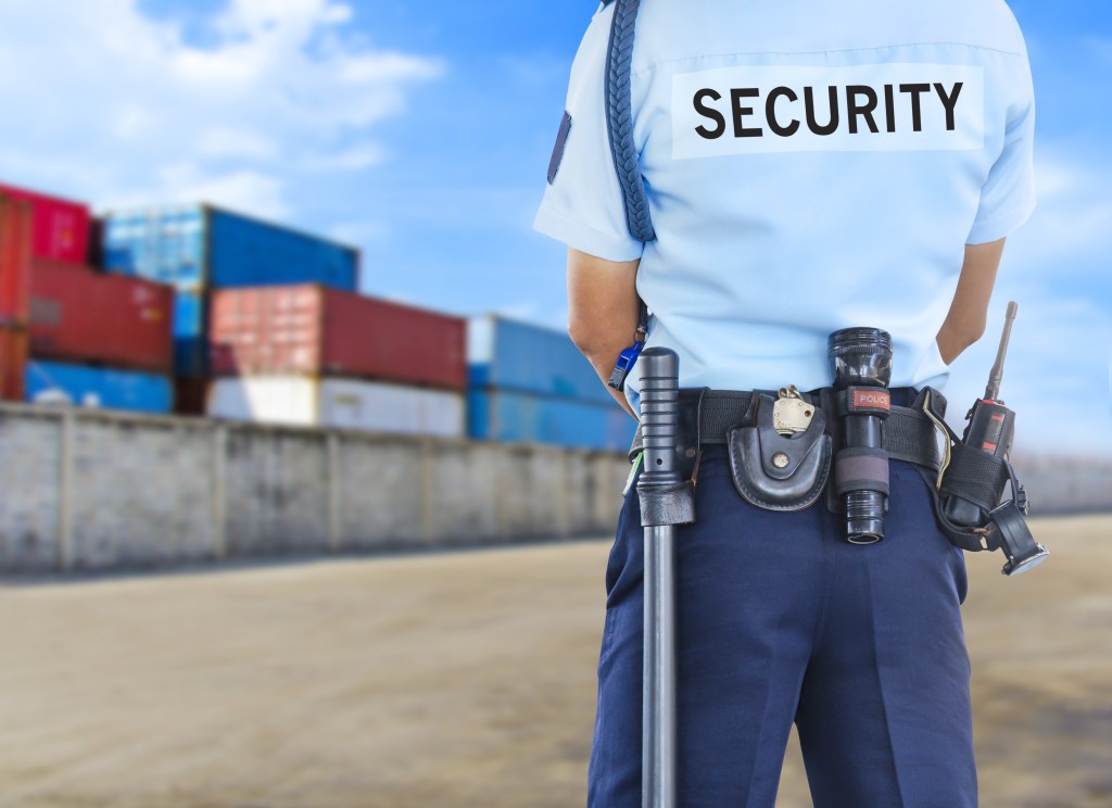 Security guard in front of shipping container