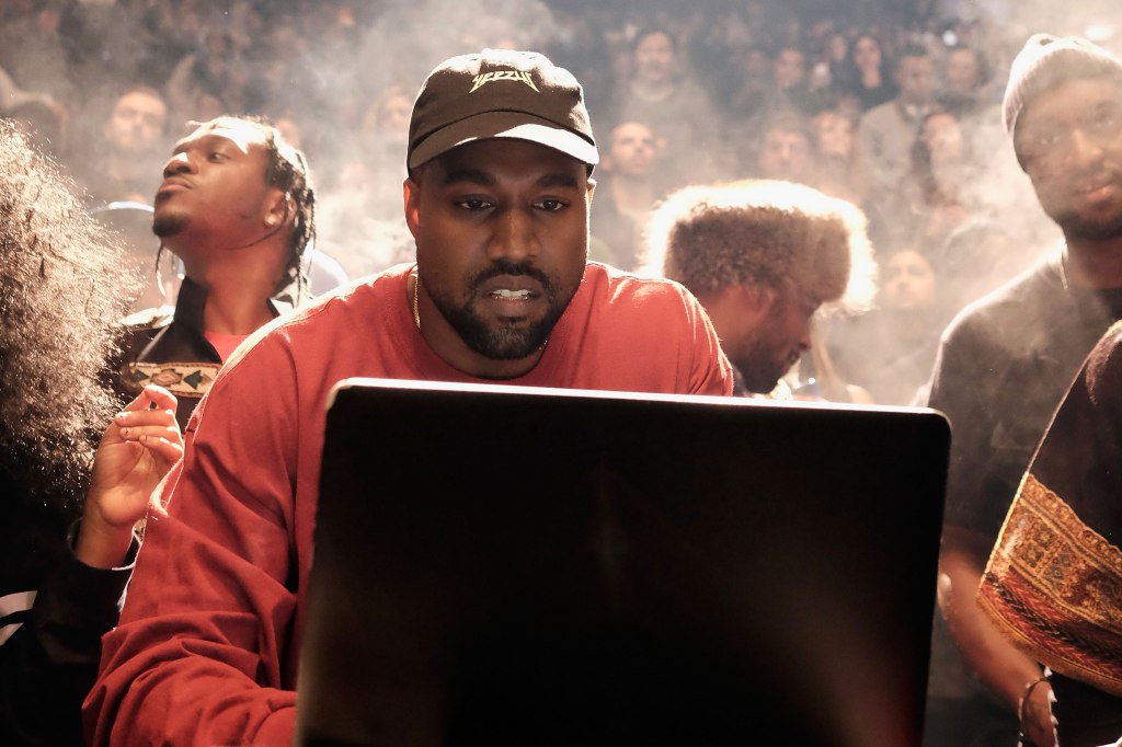 Kanye West sitting at a laptop