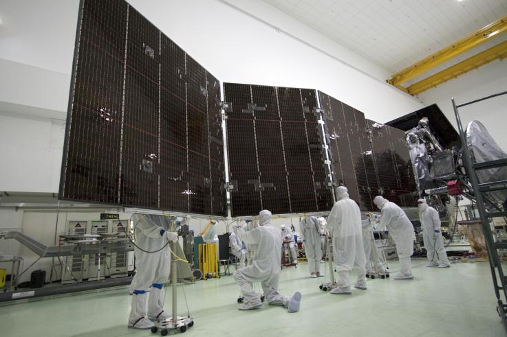 Workers at Astrotech stow one of the enormous solar panels that power Juno.