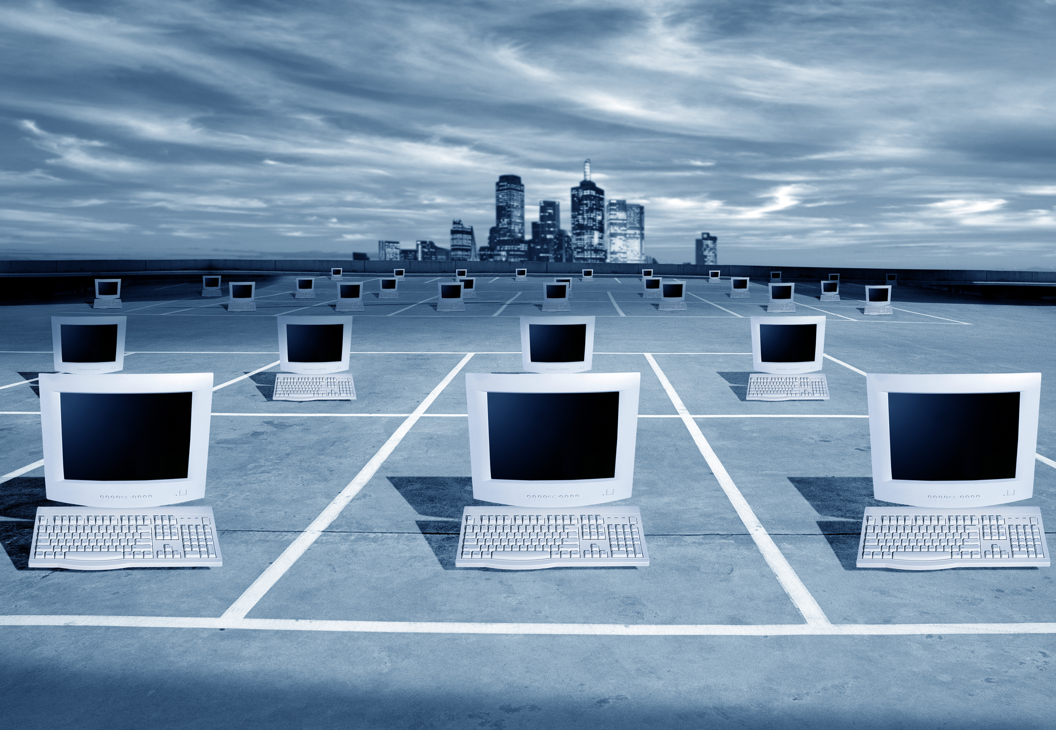 PCs on a grid in front of a city skyline.