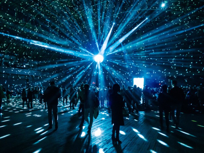 Illuminated Disco Ball Over Silhouette People In Nightclub