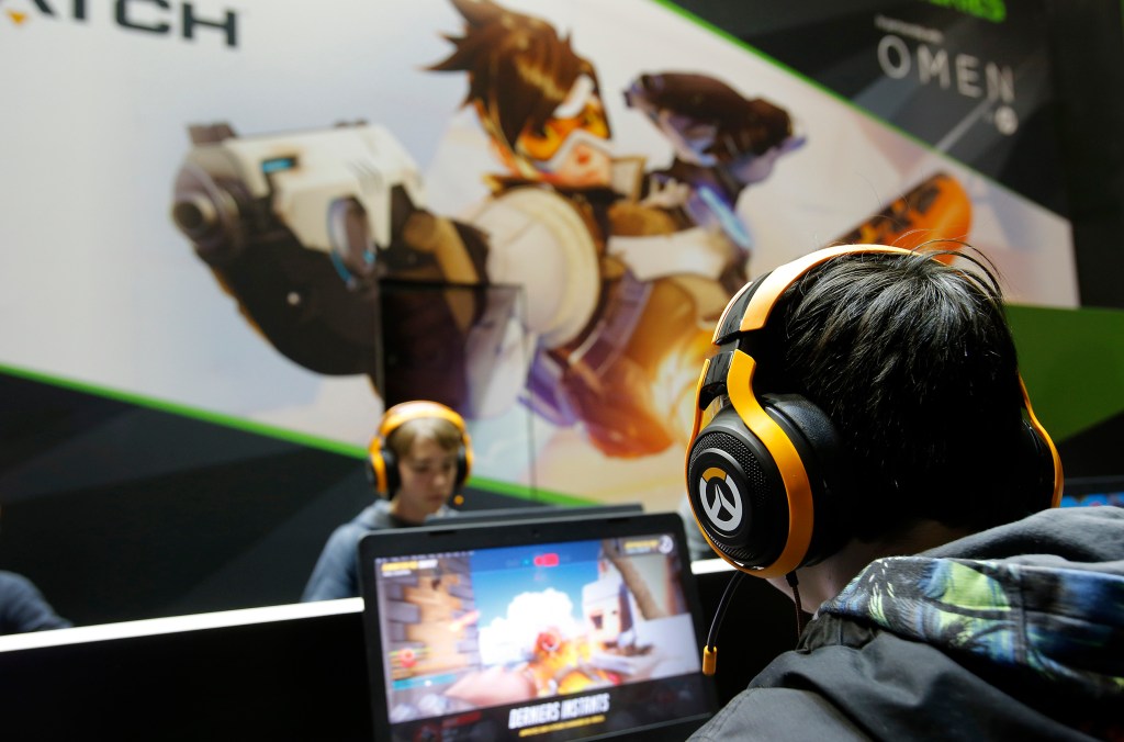 A gamer with a headphone plays the video game "Overwatch" developed by Blizzard Entertainment