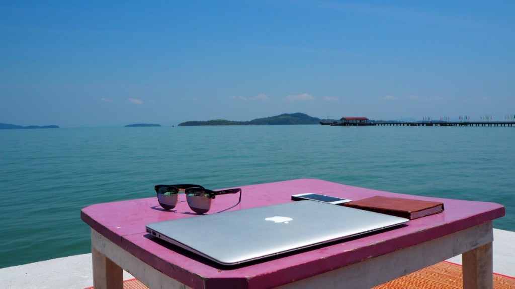 cloded laptop on table by the sea