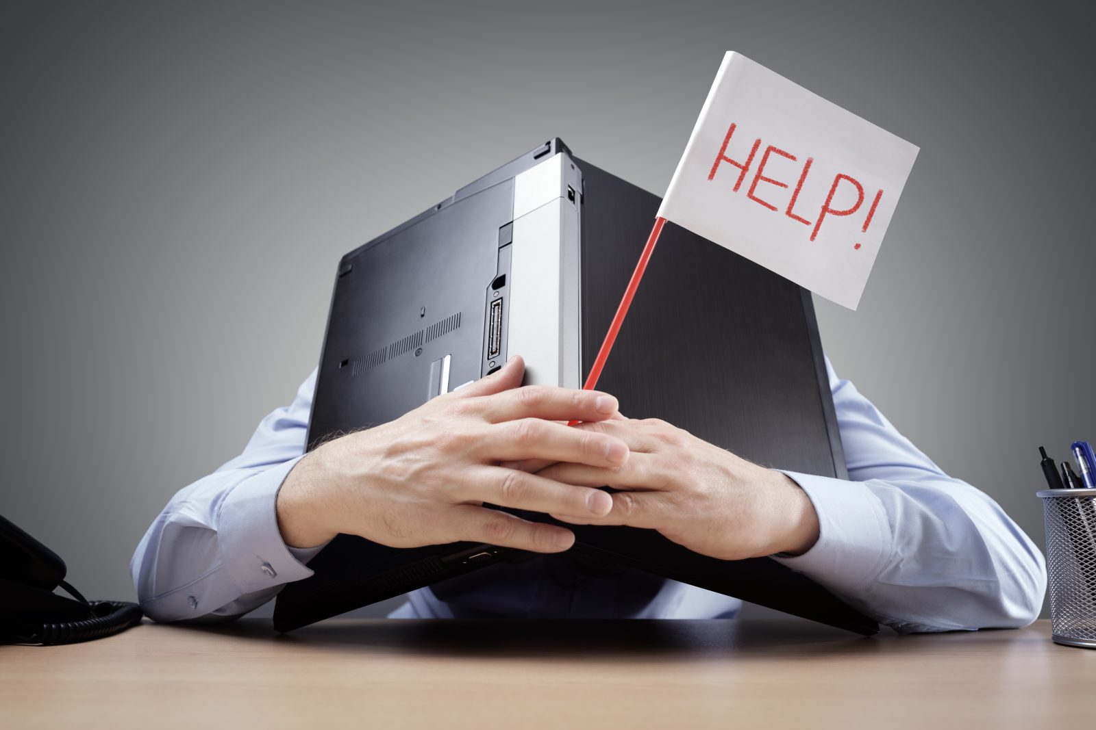 head buried in laptop with help sign