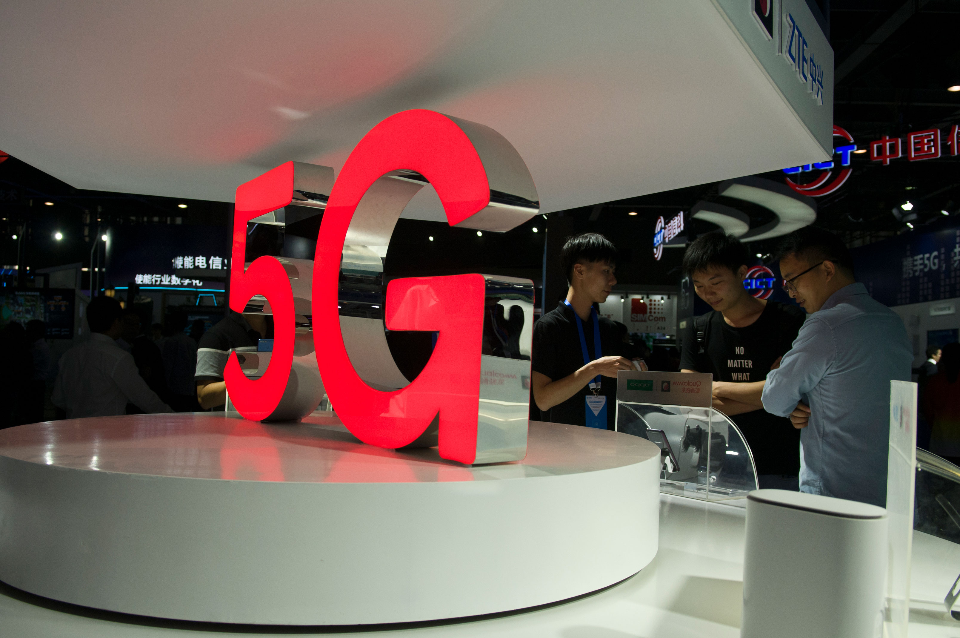 Attendees look at 5G mobile phones at the Qualcomm stand during China Mobile Global Partner Conference 2018 at Poly World Trade Center Exhibition Hall on December 6, 2018 in Guangzhou, Guangdong Province of China.