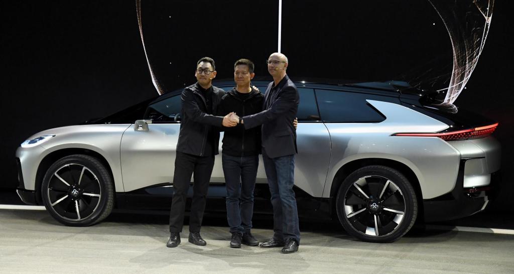 faraday future leadership poses for photo in front of EV