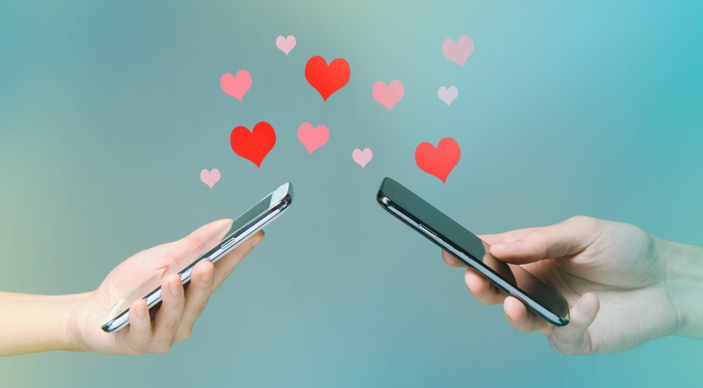 hearts floating over two smartphones