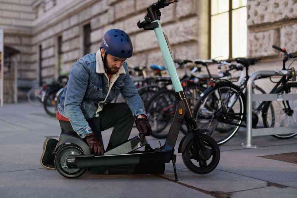 man prepares to ride tier escooter