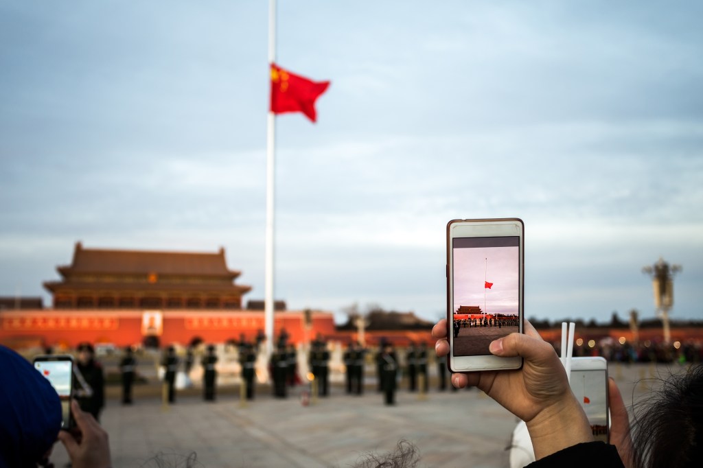 Person taking picture of Forbidden City with cell phone camera in Beijing