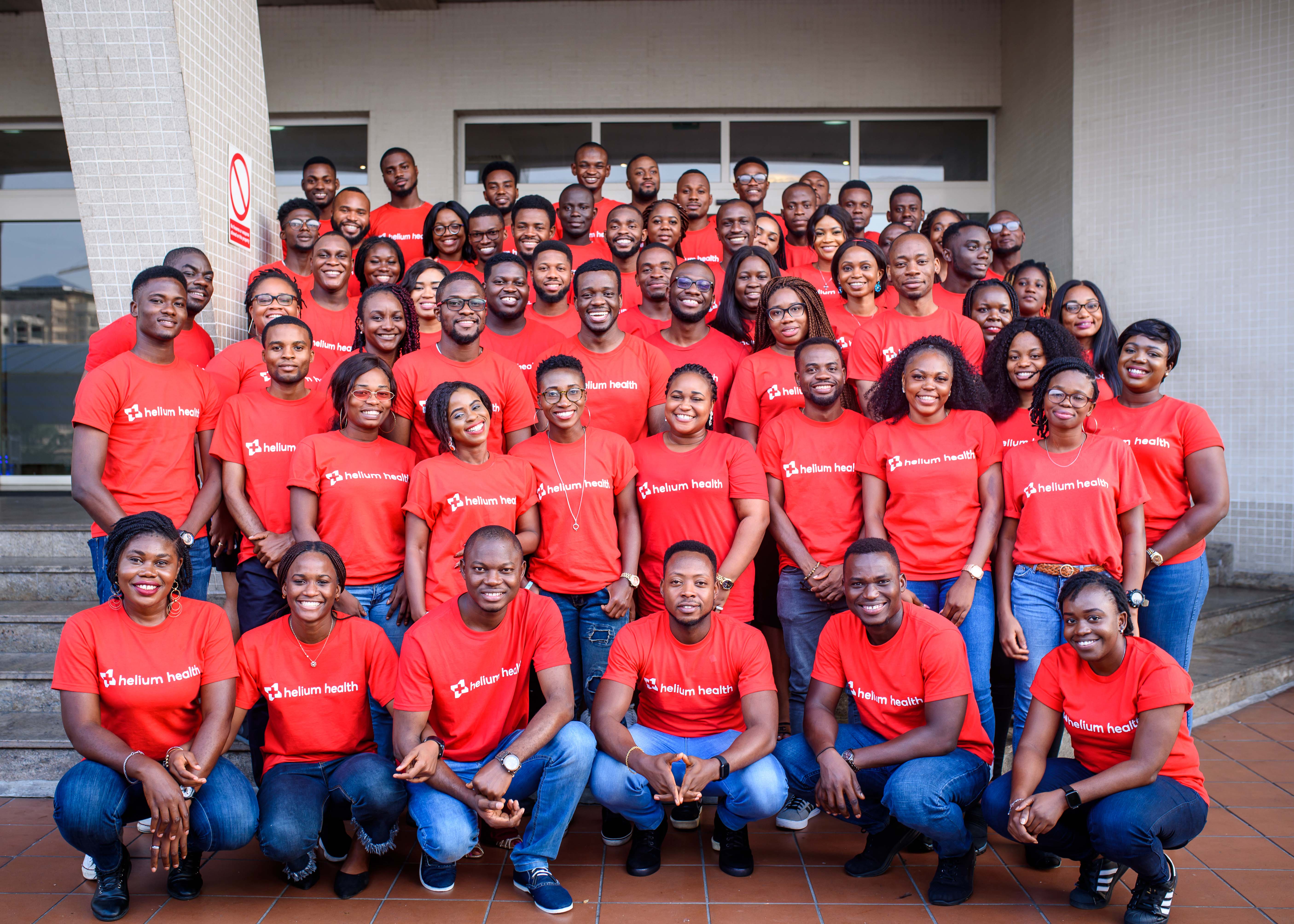 Helium Health team wearing red company t-shirts and blue jeans