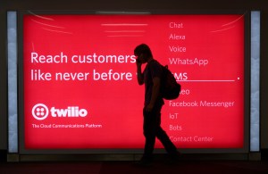 SAN FRANCISCO, CALIFORNIA - SEPTEMBER 17, 2018: A passenger waiting to board his plane walks in front of a sign advertising Twilio at San Francisco International Airport in San Francisco, California. Twilio is a cloud communications platform based in San Francisco. (Photo by Robert Alexander/Getty Images)