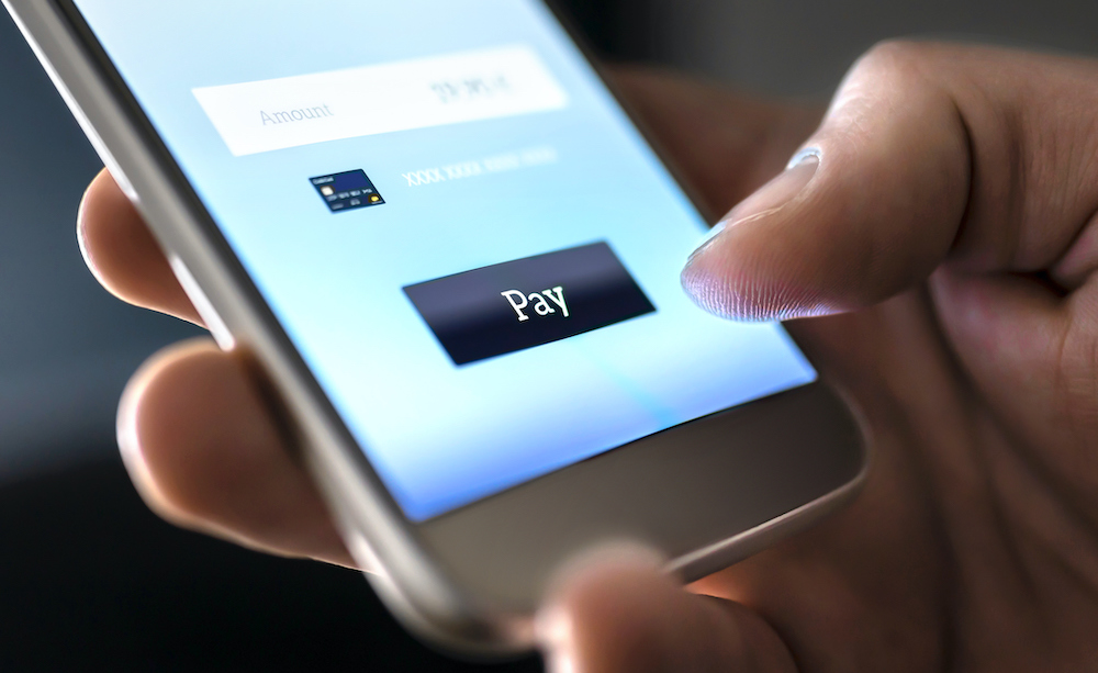 person holding smartphone about to tap the Pay button on a mobile payment app