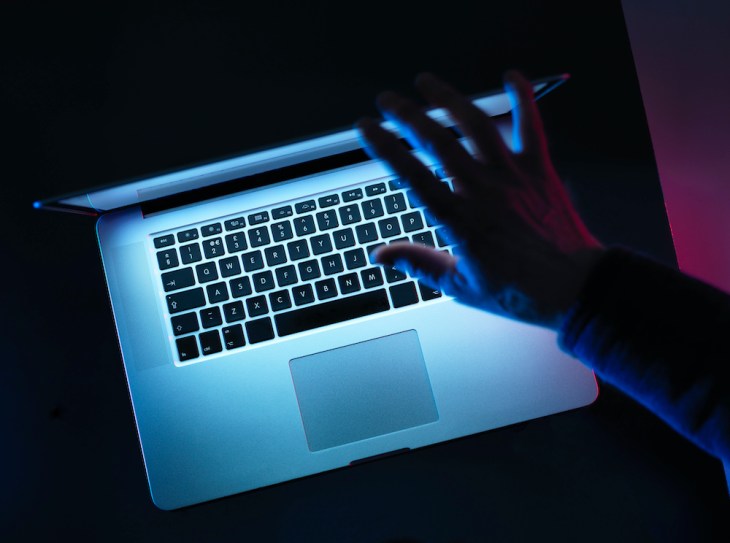 Hacking, man opening laptop computer