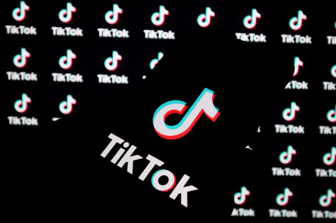 a TikTok logo is seen displayed on a smartphone