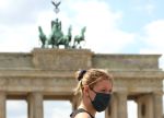 BERLIN, GERMANY - JUNE 14: A protester in front of the Brandenburg Gate wears a face mask as she attends the Unteilbar (Indivisible) demonstration march against racism, exclusion, and exploitation and for an open society on June 14, 2020, in Berlin, Germany. Organizers of the march, held amidst the ongoing coronavirus pandemic, decry the growing divisions in European society that they claim are being fueled by policies that accentuate the gap between rich and poor, which prioritize security over human rights and promote nationalism over inclusion, as well as policies leading to climate change. (Photo by Adam Berry/Getty Images)