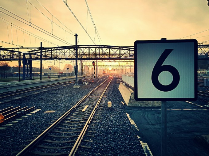 Number 6 By Railroad Tracks During Sunset