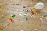 Burst balloons and party streamers on wooden floor