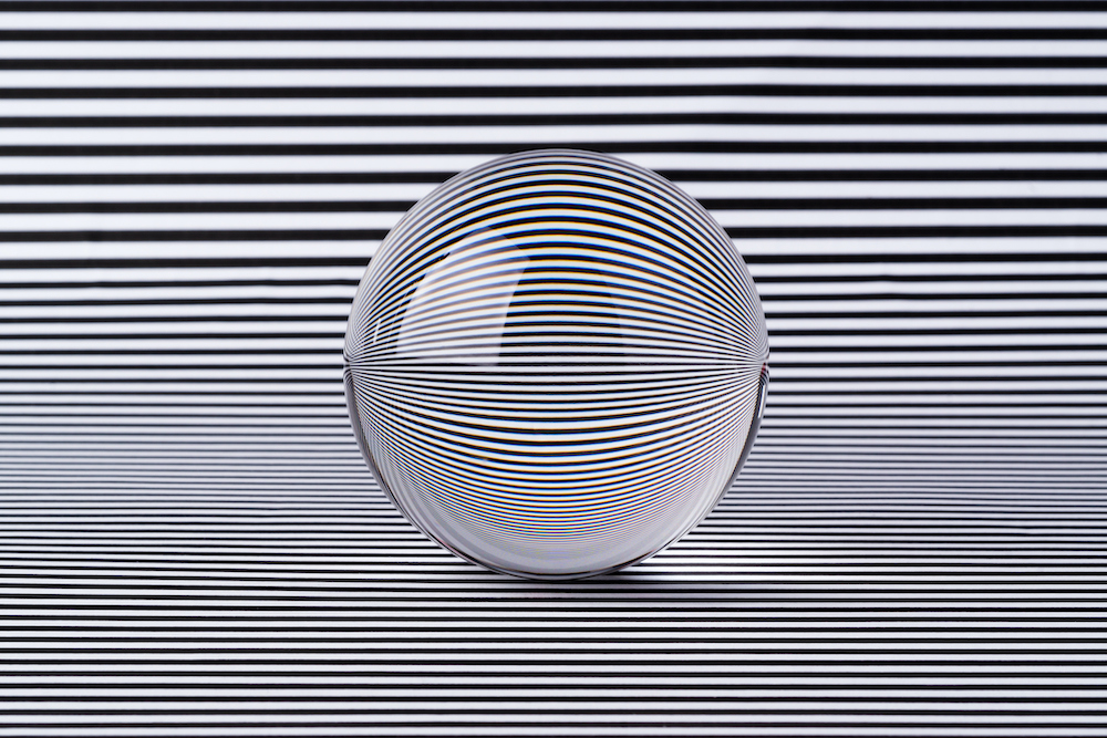 Crystal Ball Refraction Illusion on Black and White Striped Pattern.