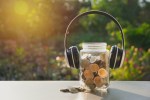 Coins in jar with money stack and headphone, Concept finance, accounting, business and saving investment.