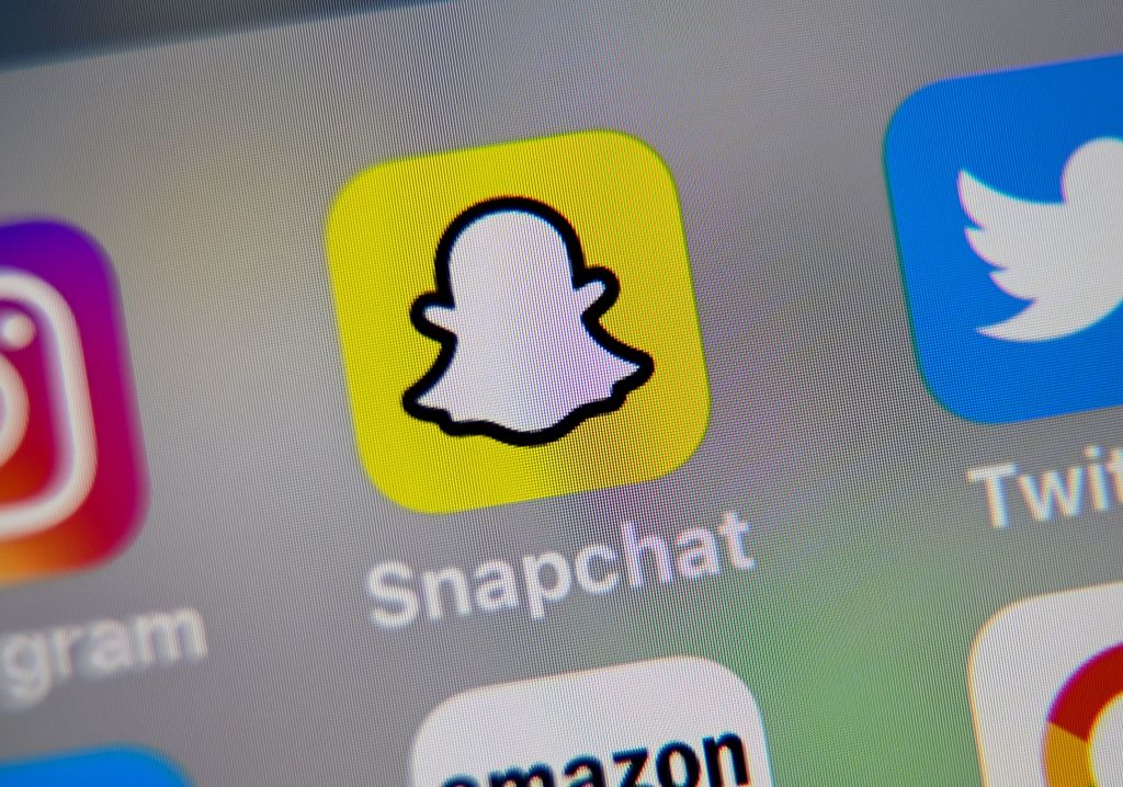 A picture taken on October 1, 2019 in Lille shows the logo of mobile app Snapchat displayed on a tablet.