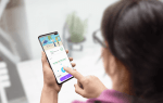 Photo of a woman holding a smartphone with English learning app ELSA opened
