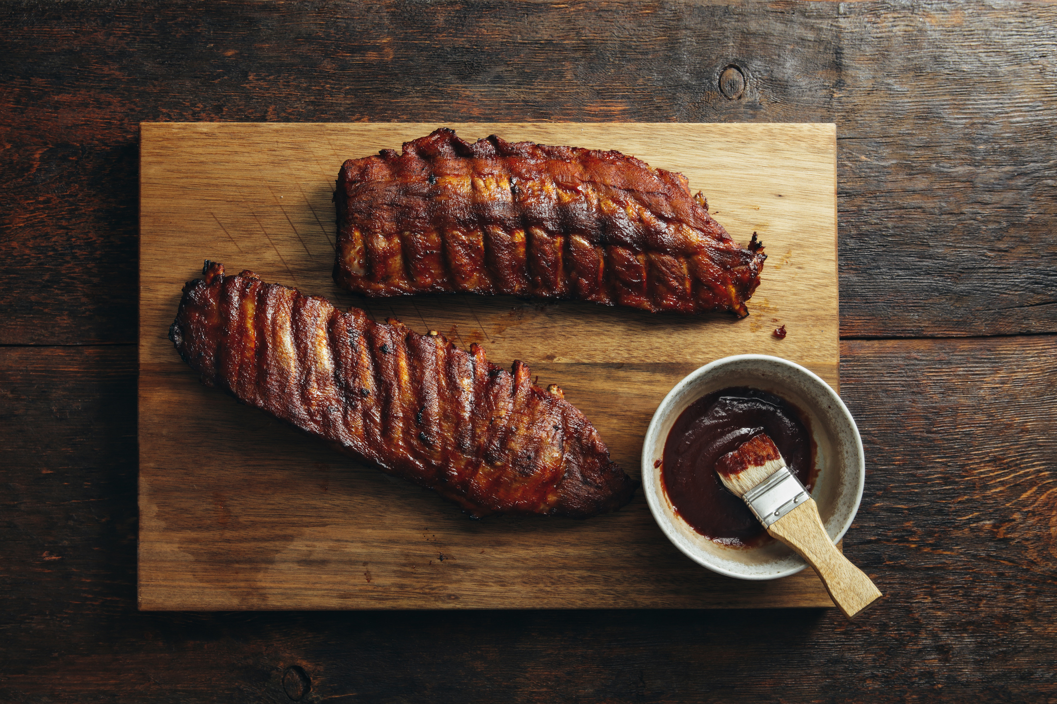 Grilled pork ribs with barbecue sauce on wooden background