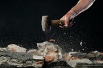 Smashing brick work with hammer