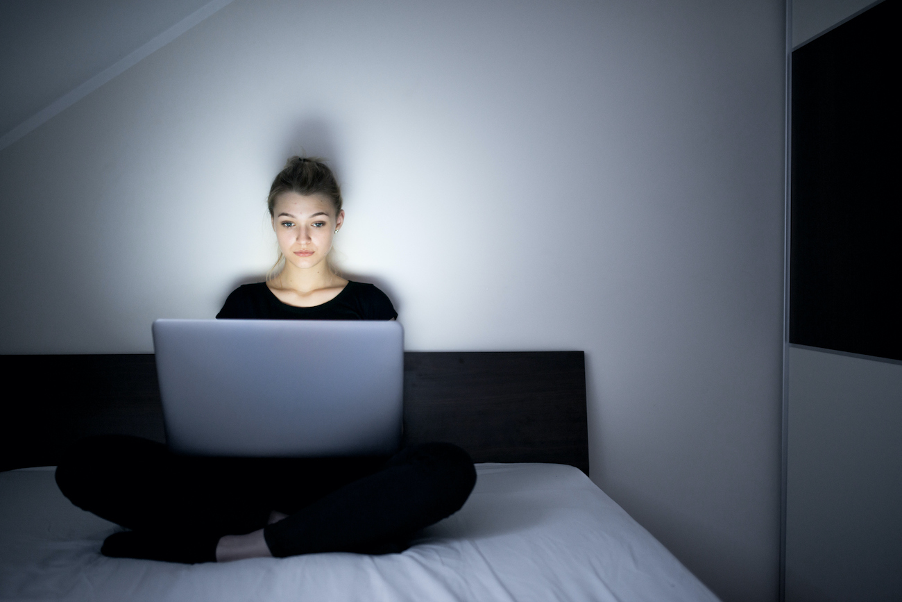 Teenage Girl Using Laptop in Bed Late at Night.
