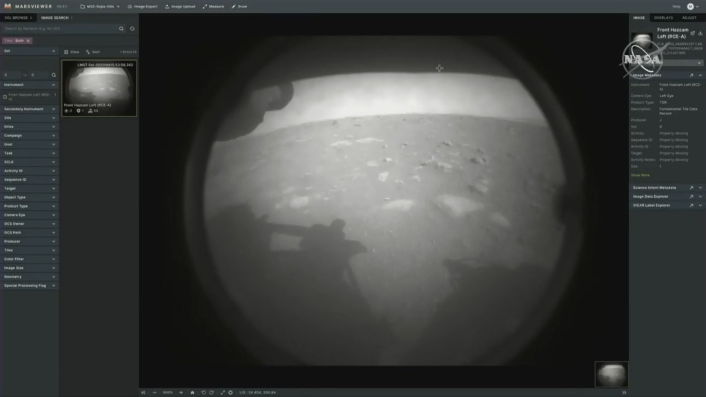 The first image sent back by Mars rover Perseverance showing its own shadow against a Martian plain in black and white.