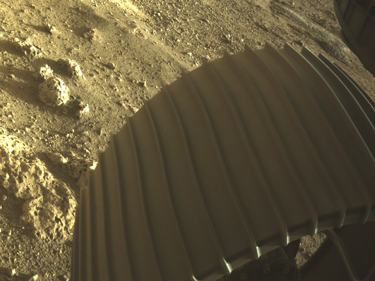 Foto de la rueda de la diligencia de Marte y rocas en la superficie.
