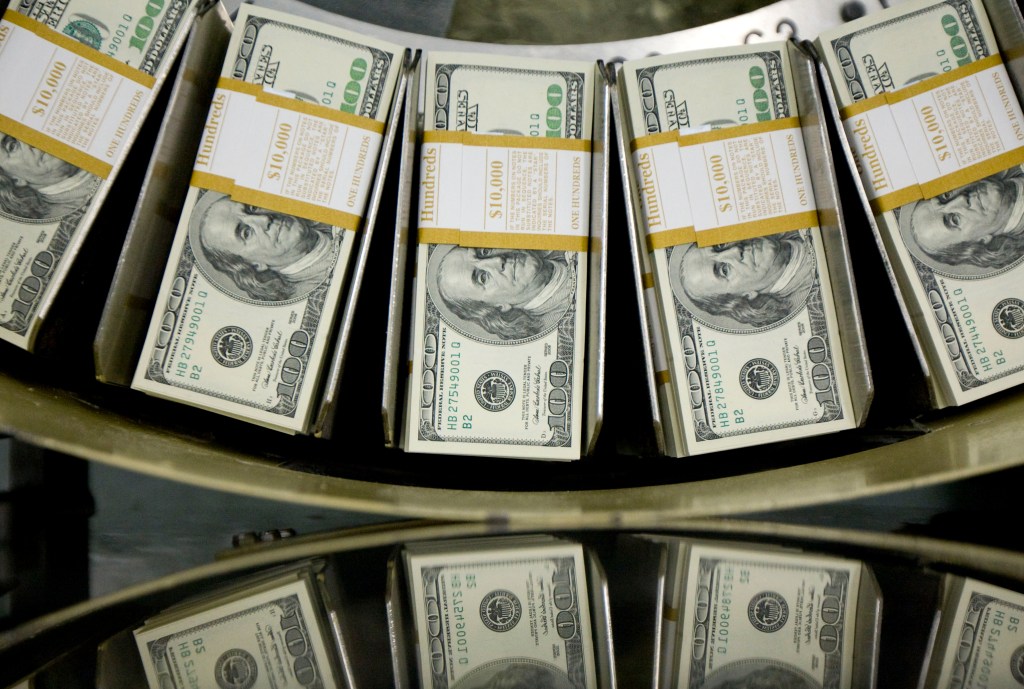 Stacks of one hundred dollar bills pass through a circulator machine at the Bureau of Engraving and Printing in Washington, D.C