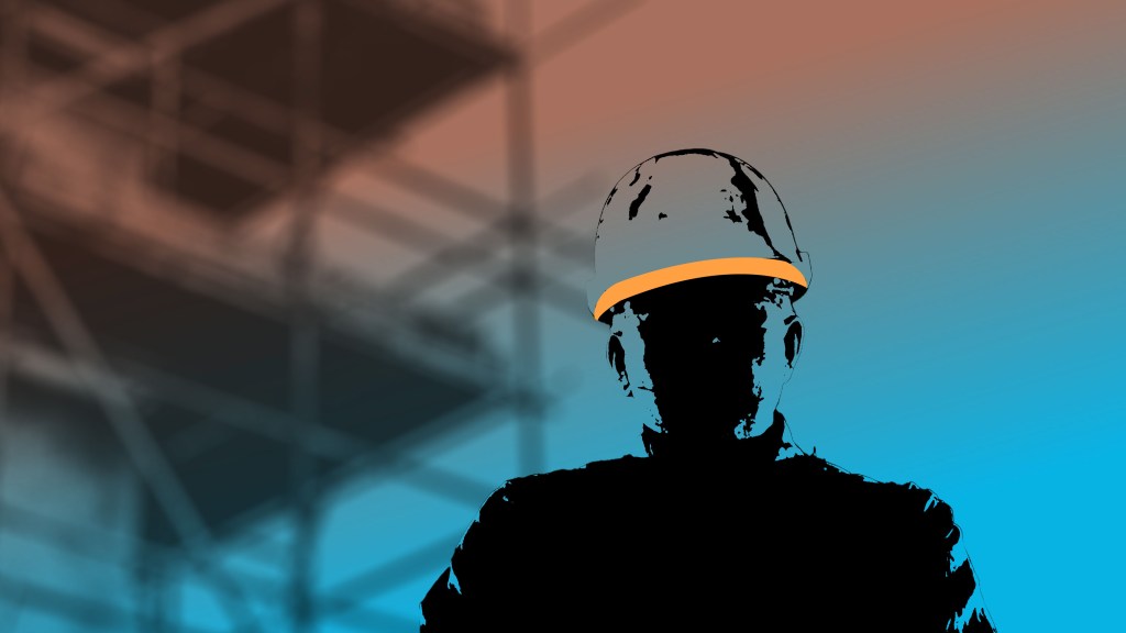 silhouetted man in foreground wearing hardhat, scaffolding and construction in background
