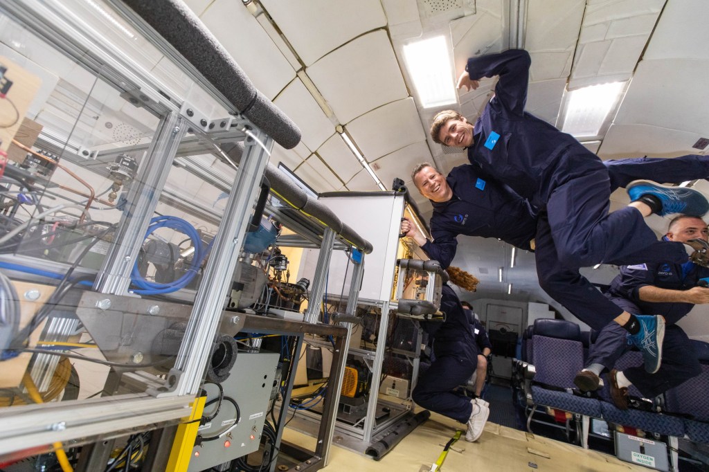 Eckhard Groll and Leon Brendel test a fridge in zero G on a plane.