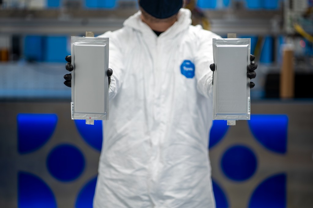 Solid Power manufacturing engineer holds two 20 ampere hour (Ah) all solid-state battery cells.