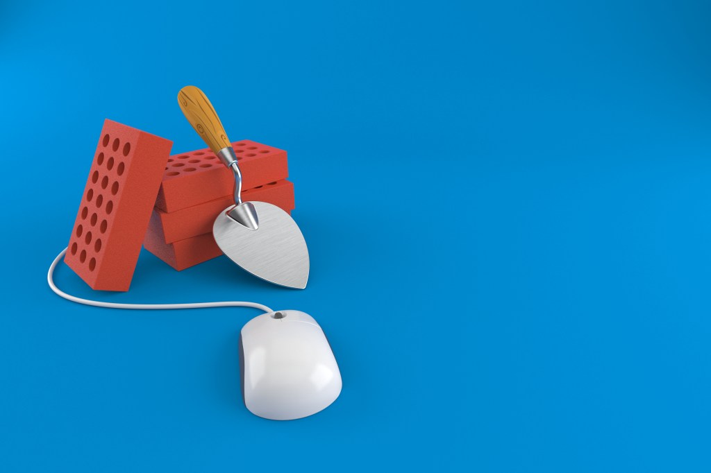 Image of trowel and bricks with a computer mouse against a blue background.