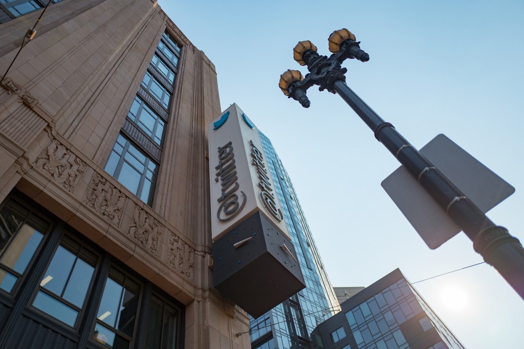 A photograph looking upward at Twitter HQ in the daytime: a tall, stone building with a marquee that says Twitter