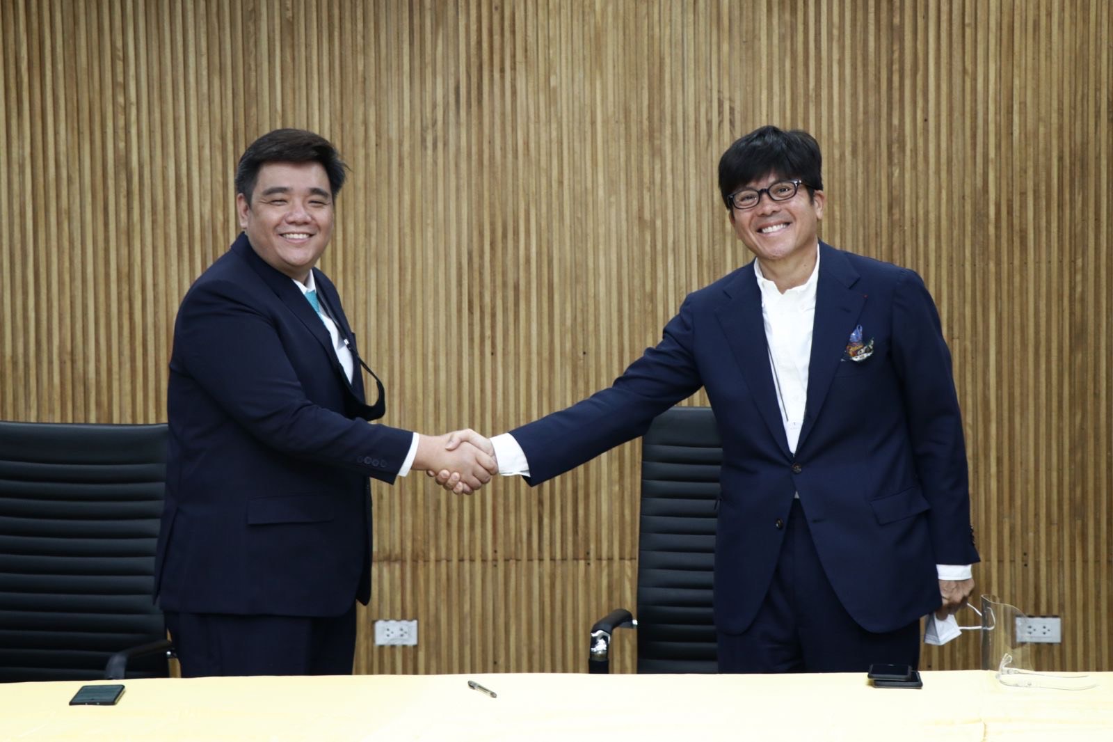 Steve Sy, the CEO of Great Deals, and William Chiongban, CEO of Fast Group, sign the contract for the companies' strategic partnership