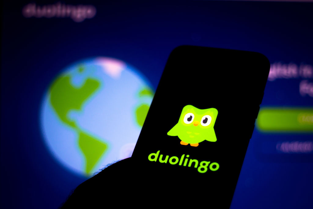 في هذه الصورة التوضيحية، يظهر شعار Duolingo معروضًا على الهاتف الذكي.