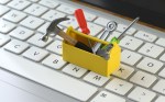 Image of a yellow toolbox sitting on a keyboard to represent a digital ops toolbox to allow for hyperautomation.