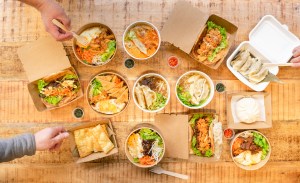 An overhead photo of people eating from takeaway boxes