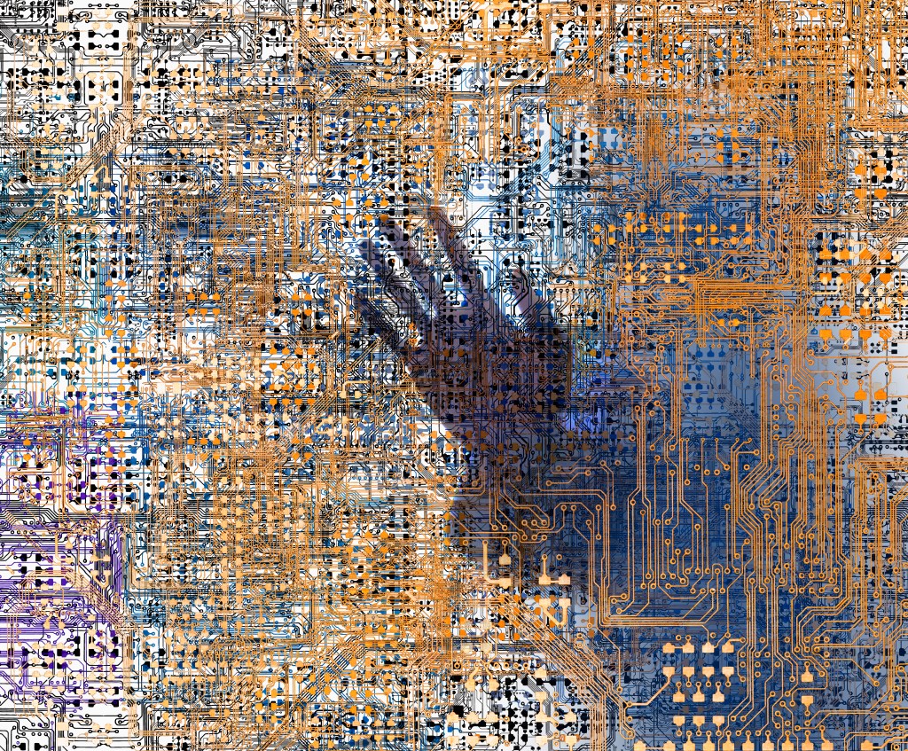 Image of a hand behind a complex circuit network to represent humanity in information security.