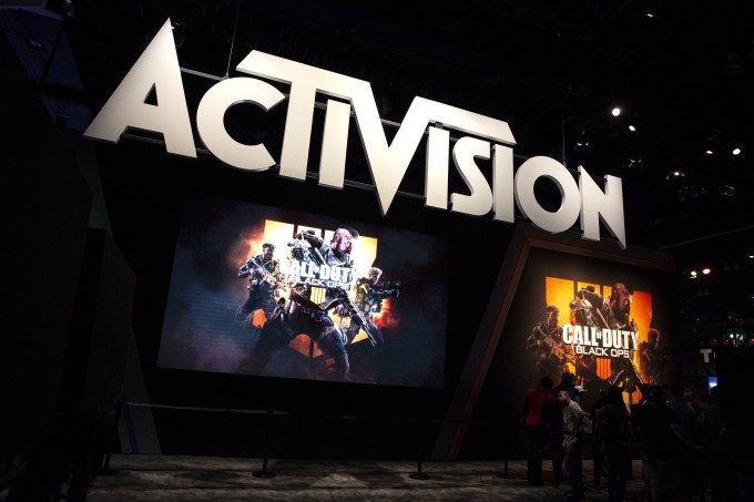 Attendees stand next to signage for Activision Blizzard Inc.