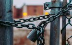 A padlocked chain holds a fence or gate closed