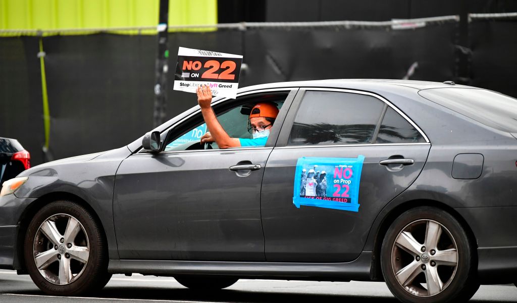 Image of a driver in a car urging a vote against Prop 22.