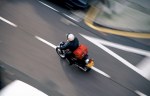 Image of a motorcycle courier speeding down a street.